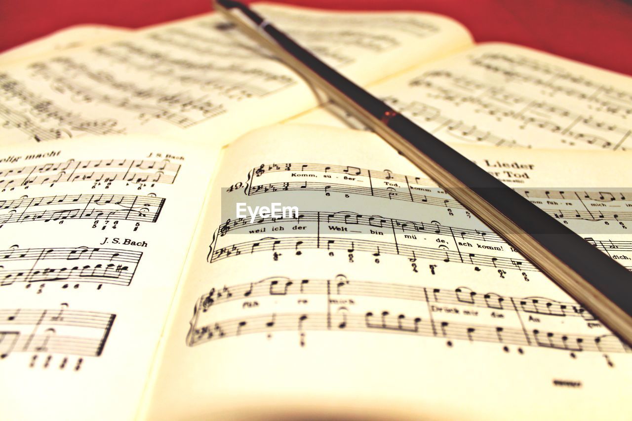 High angle view of musical noted and bow on table