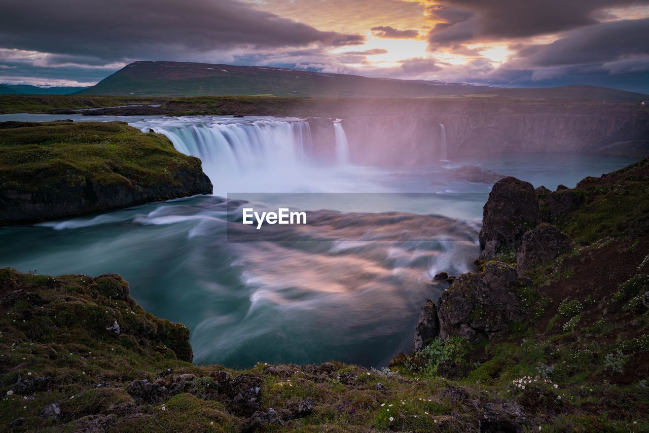 Scenic view of waterfall against sky