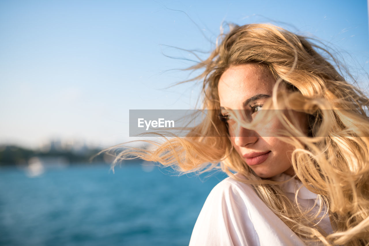 Beautiful young woman against sea