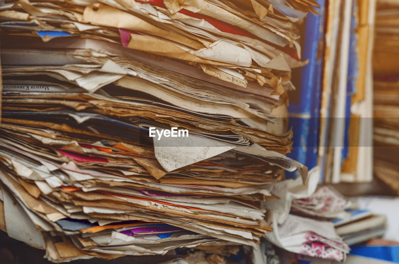 Documents, old papers in folders on shelves are stacked in a mess