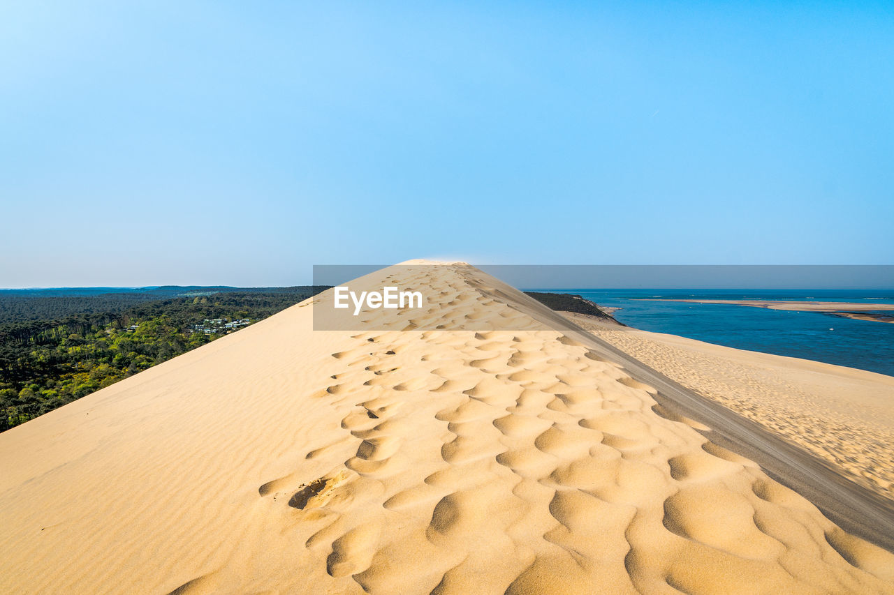 Scenic view of beach against clear blue sky