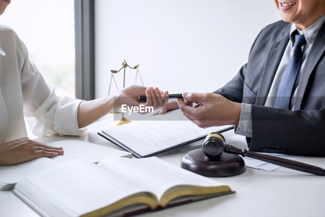 Woman giving pen to judge at desk