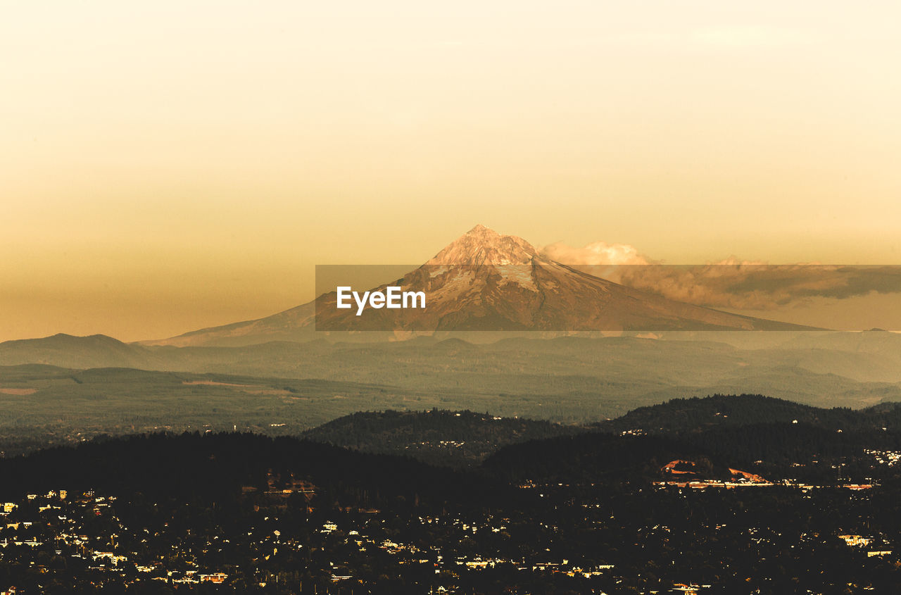 Aerial view of townscape and mountains against clear sky