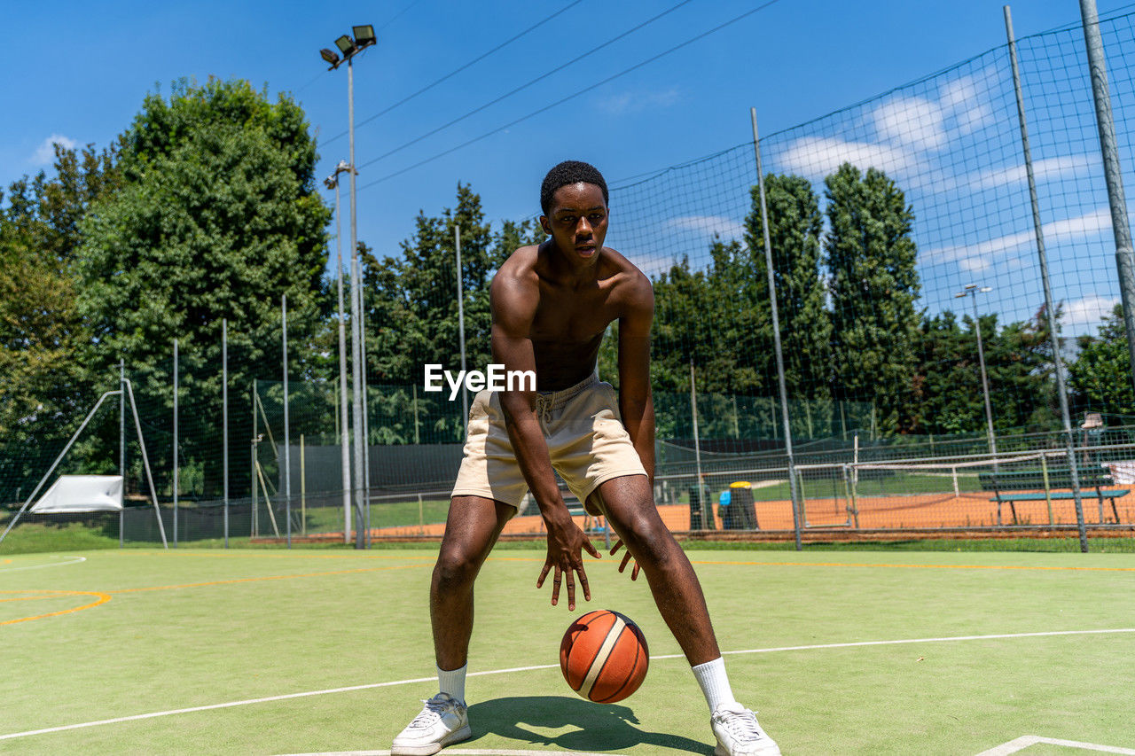 Young african american athlete basketball player in action dribbling on artificial grass field