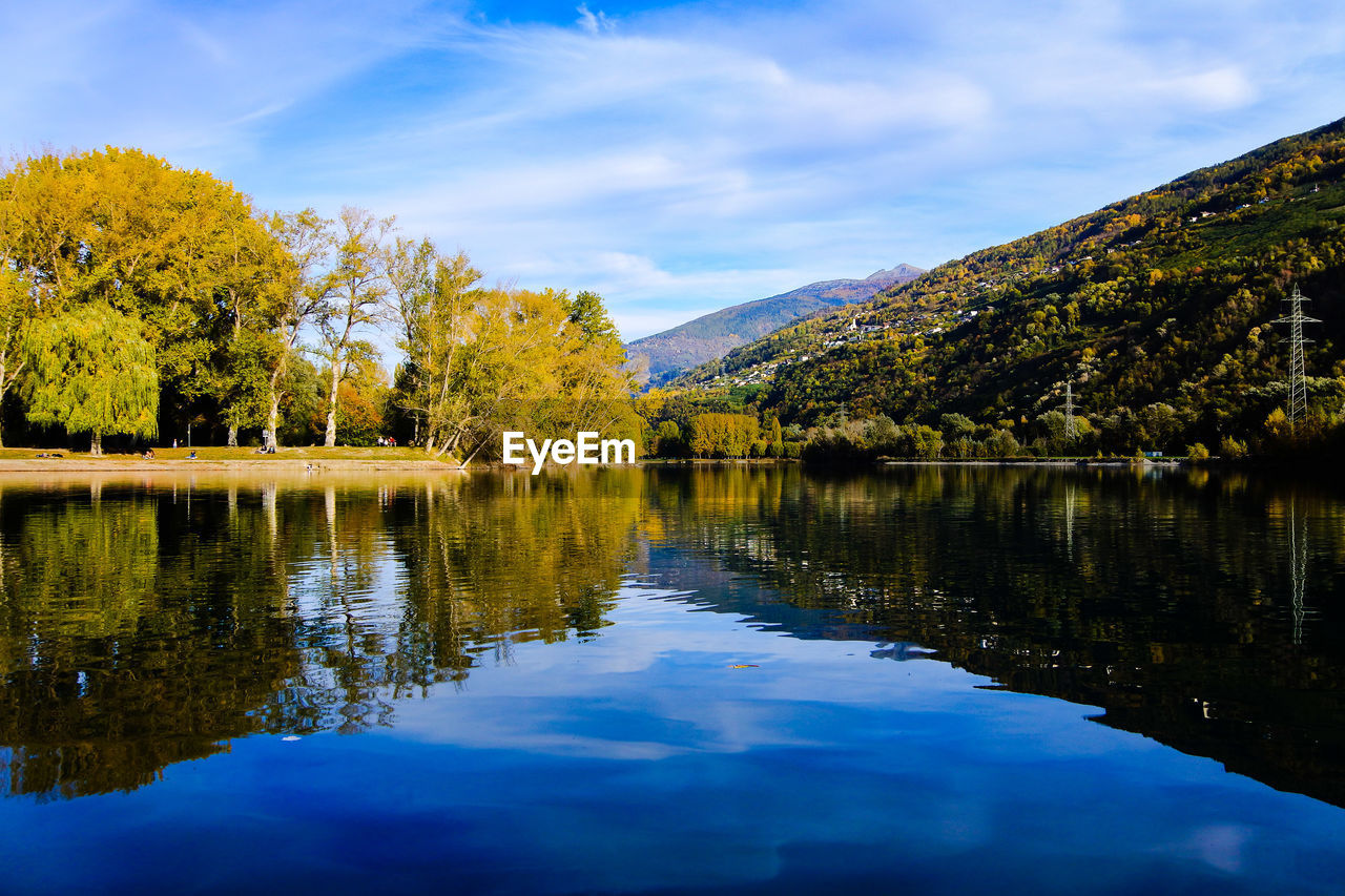 Scenic view of lake by trees against sky