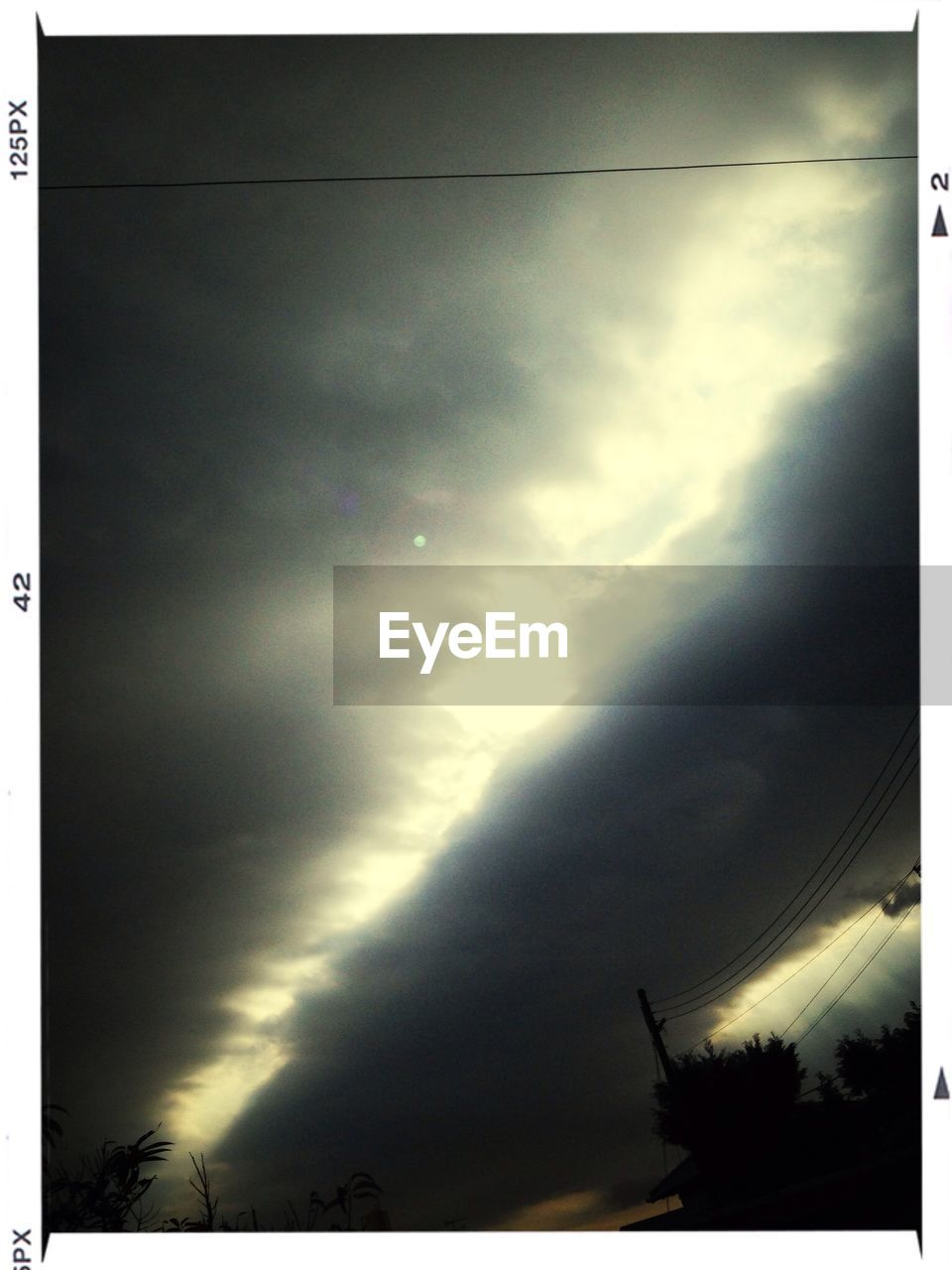 LOW ANGLE VIEW OF POWER LINES AGAINST CLOUDY SKY