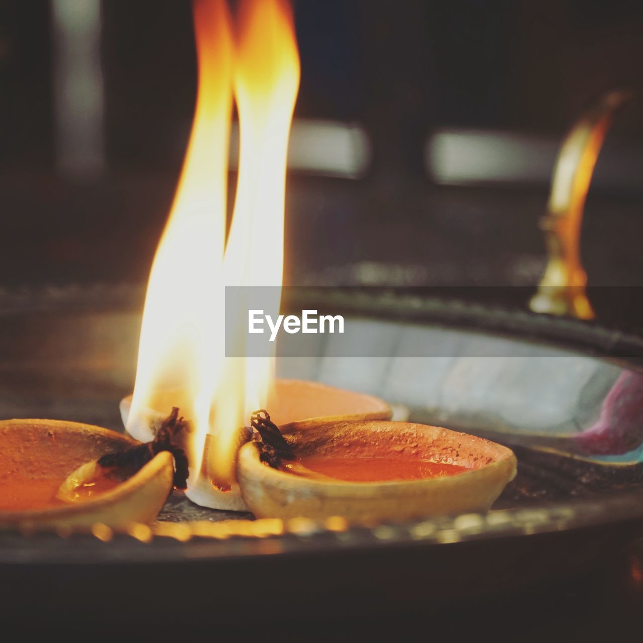 CLOSE-UP OF LIT CANDLES ON BURNING CANDLE