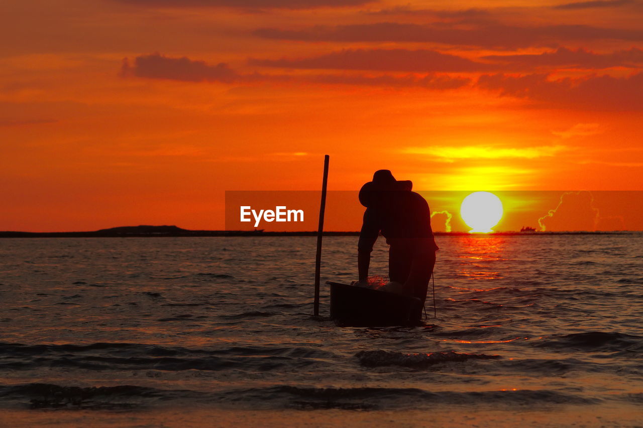 A silhouette of fisherman at sunset