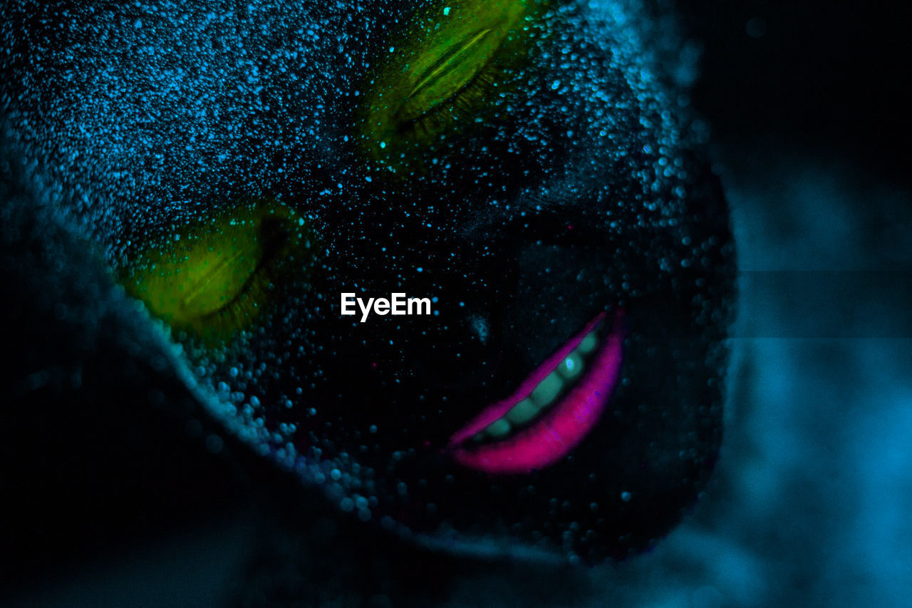 Woman with eyes closed in neon make-up