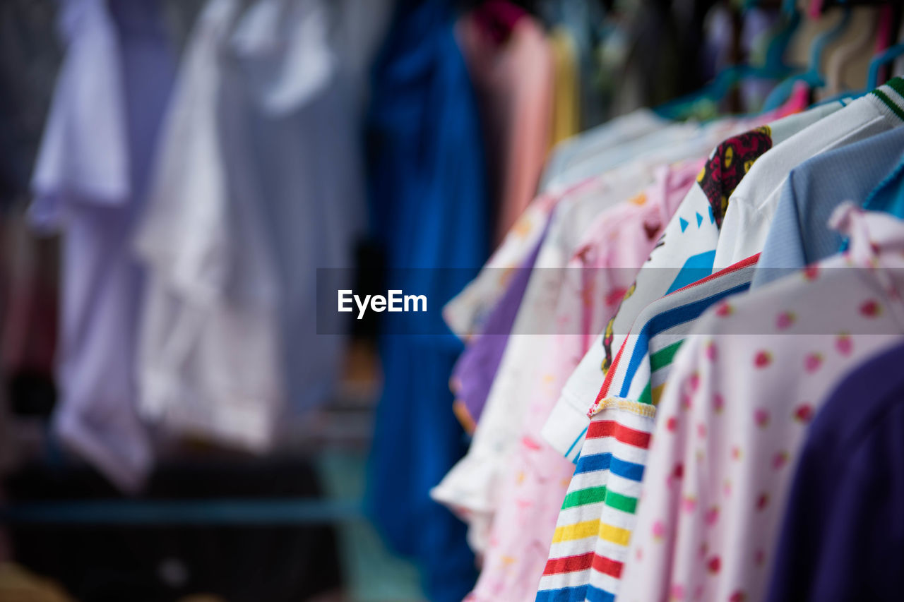 Close-up of clothes hanging in rack at store