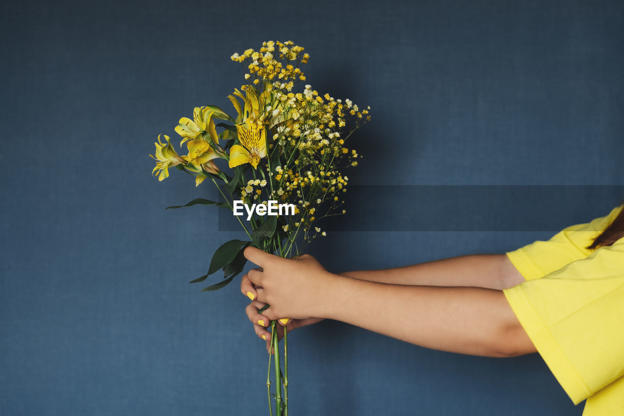 Chrysanthemum bouquet in girl's hands on white background. flat lay, top view concept