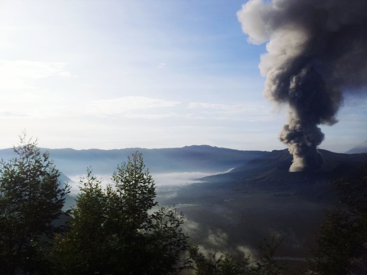 Smoke erupting at mt bromo against sky