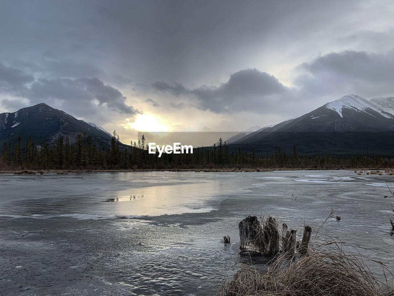 Scenic view of lake by snowcapped mountains against sky