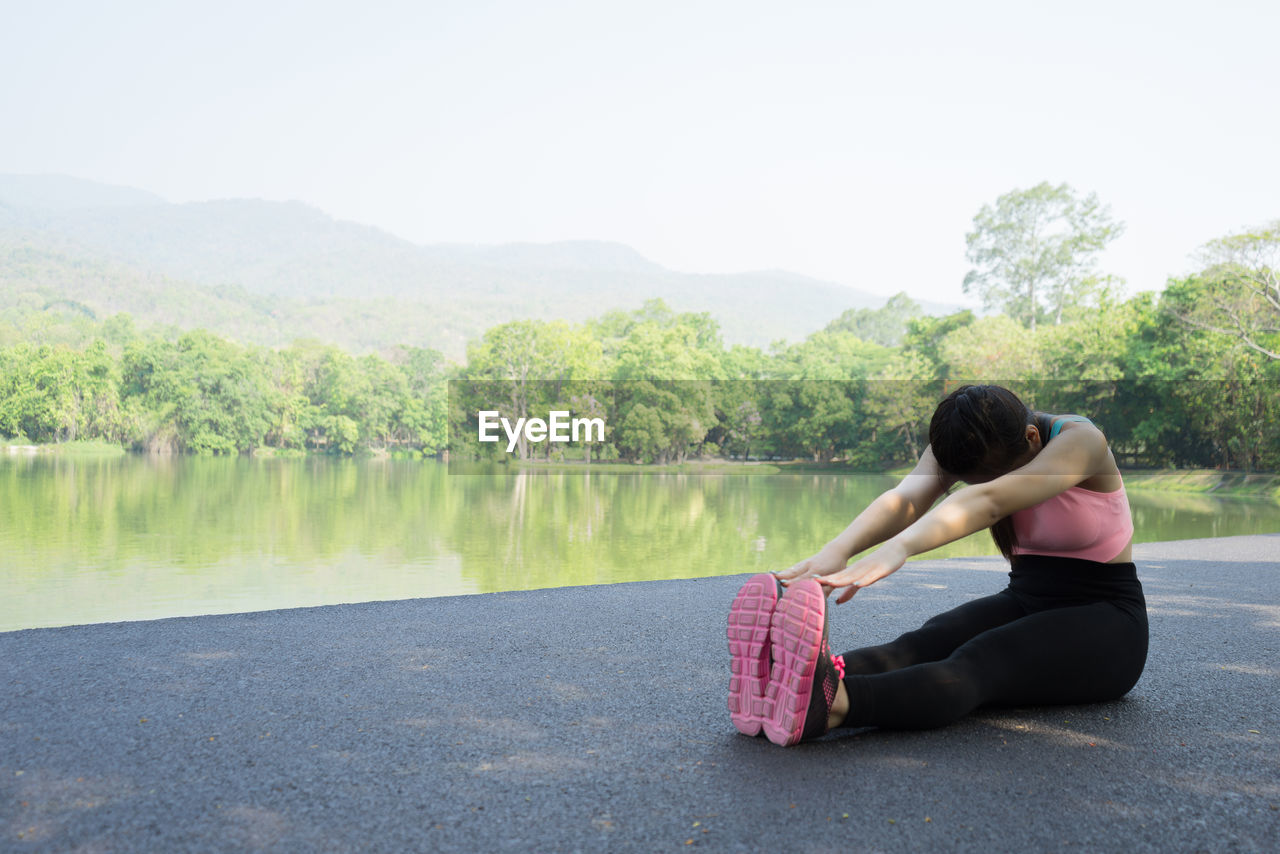 Woman exercising by lake