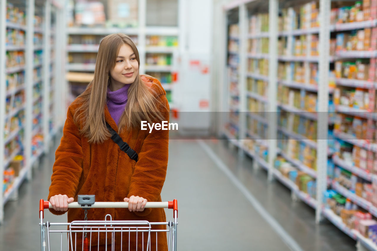 Young woman looking away while standing in store