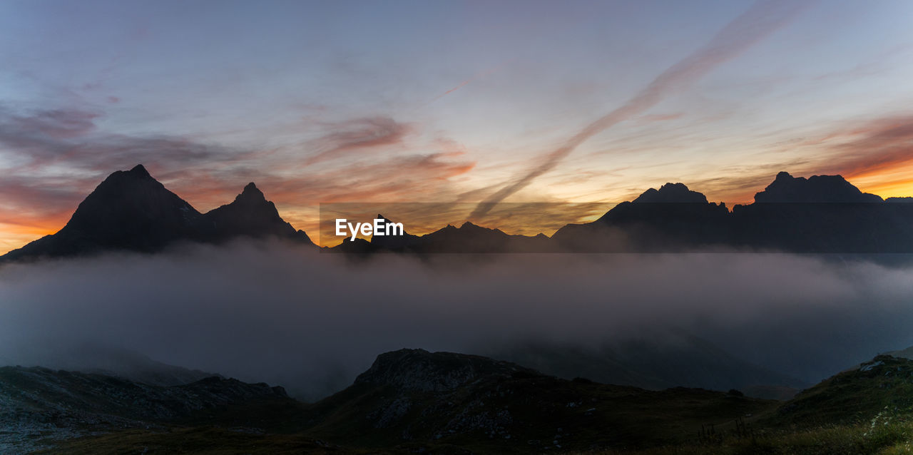 Scenic view of silhouette mountains against sky at sunset