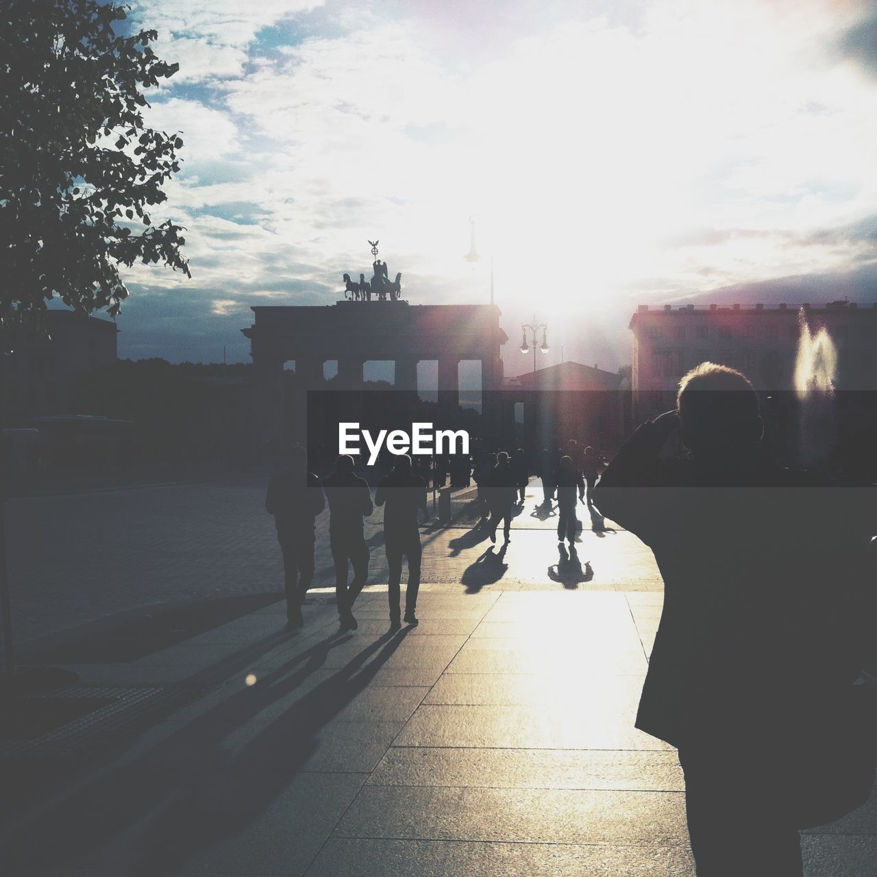 Silhouette people walking in front of built structure