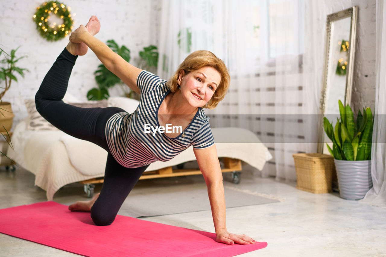 Mature woman doing sports on mat at home