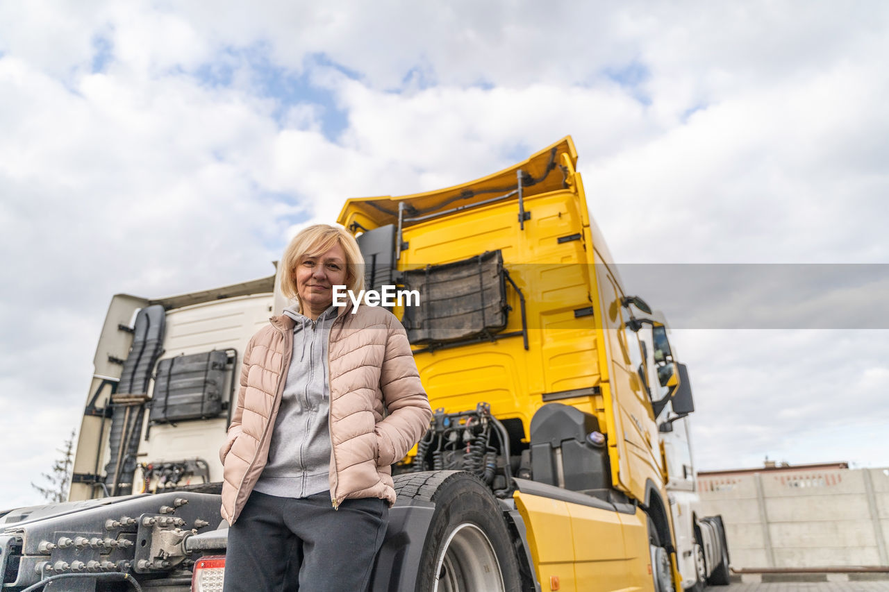 Low angle view of woman standing by truck