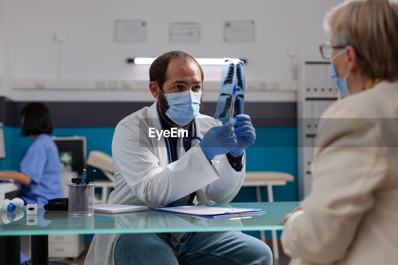 midsection of female doctor examining patient in laboratory