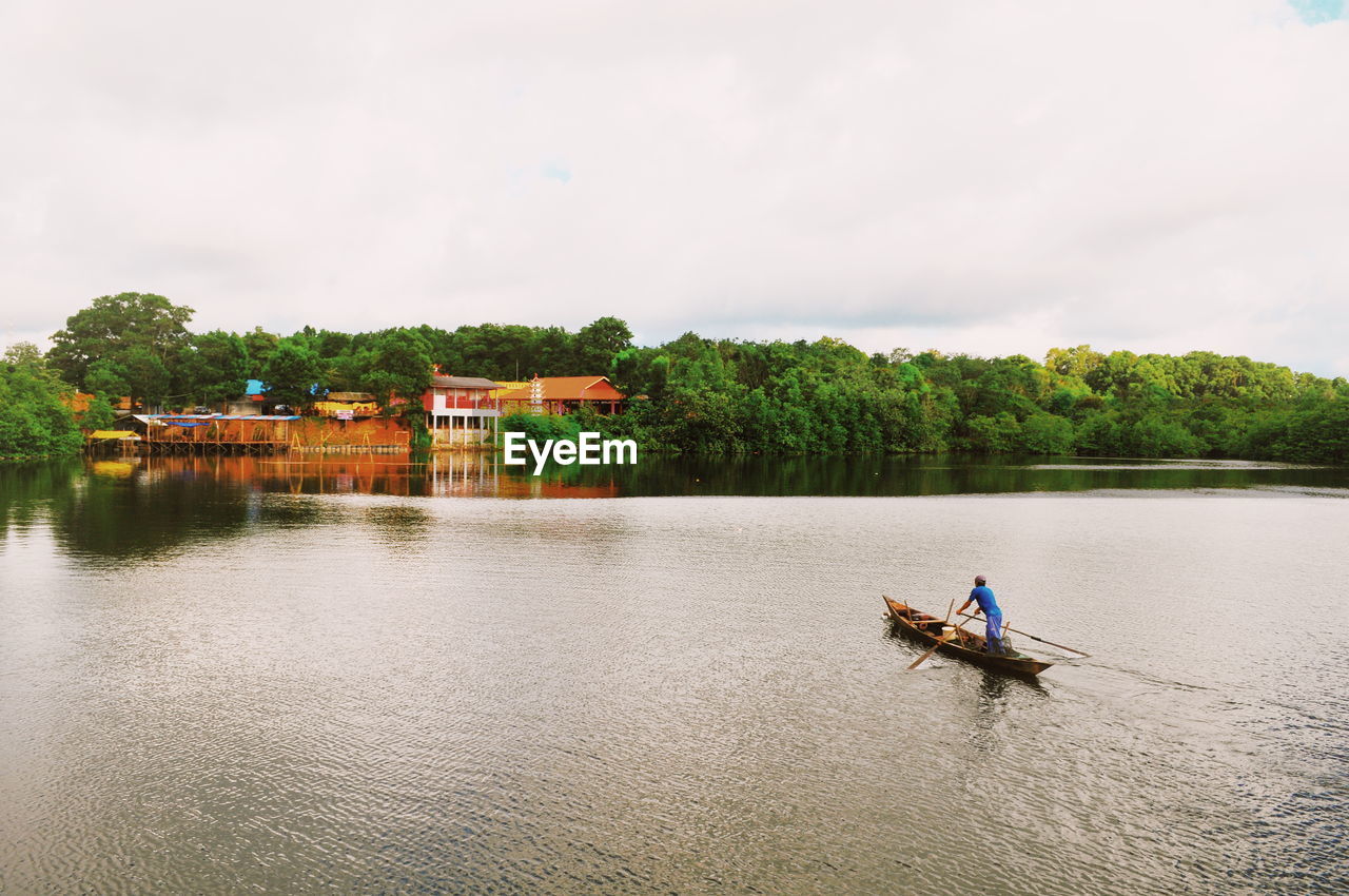 High angle view of man rowing fishing boat on lake 