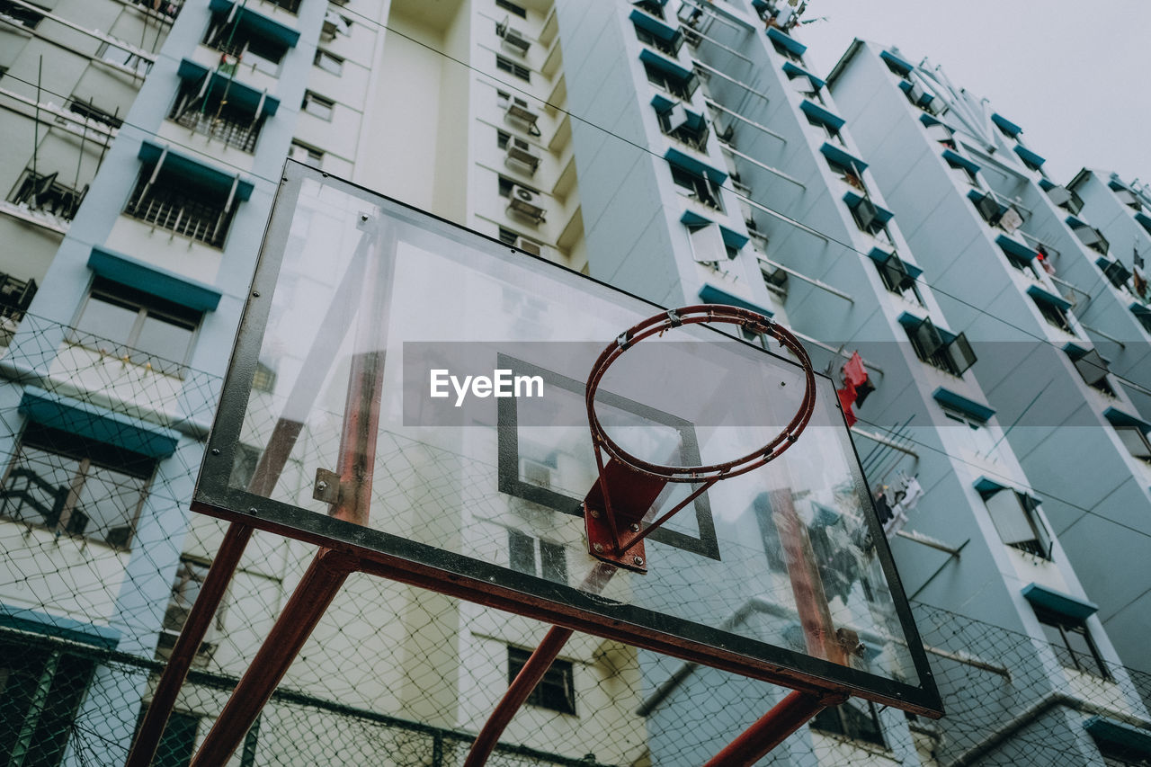 Low angle view of basketball hoop against buildings