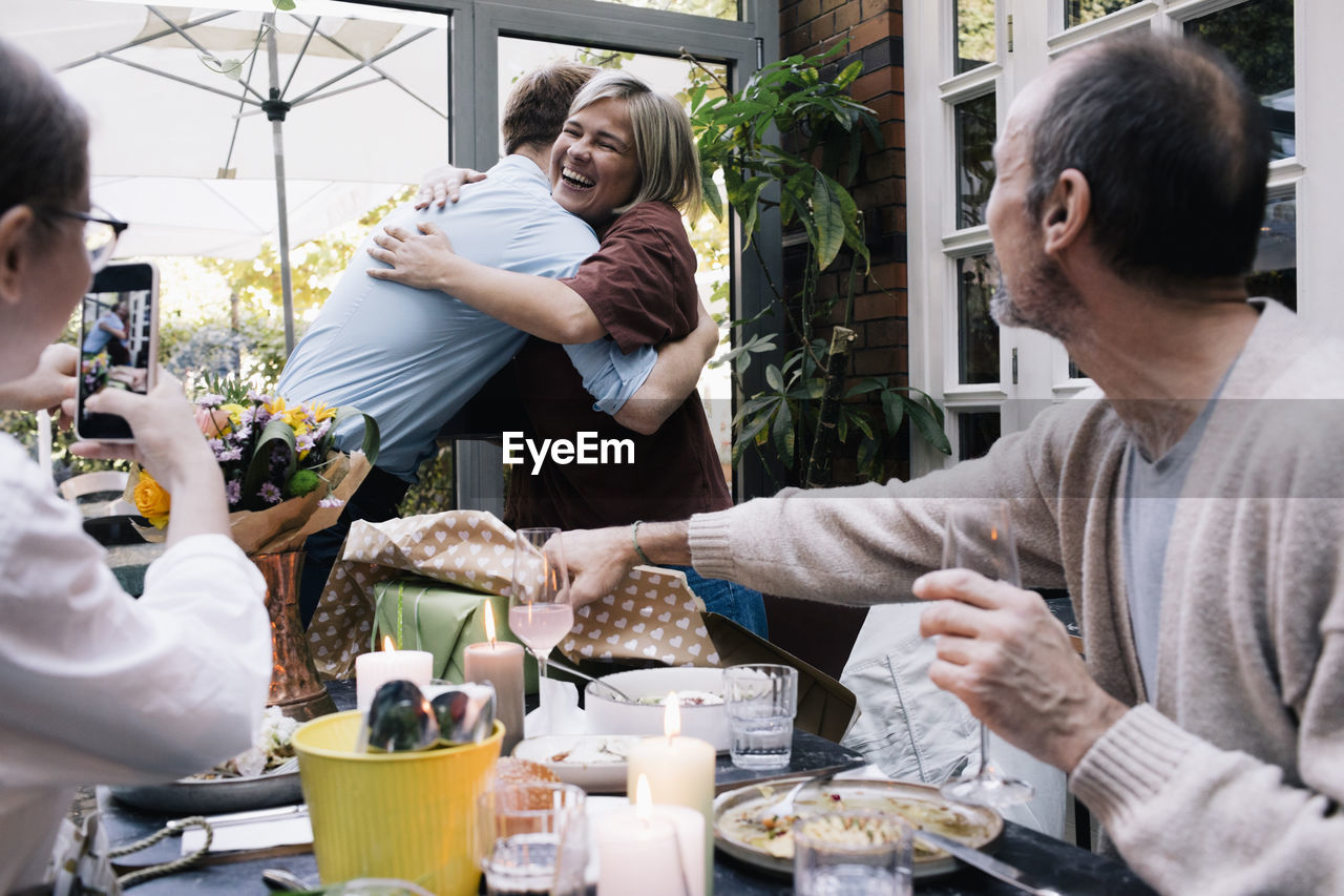 Happy parent embracing son during party at restaurant