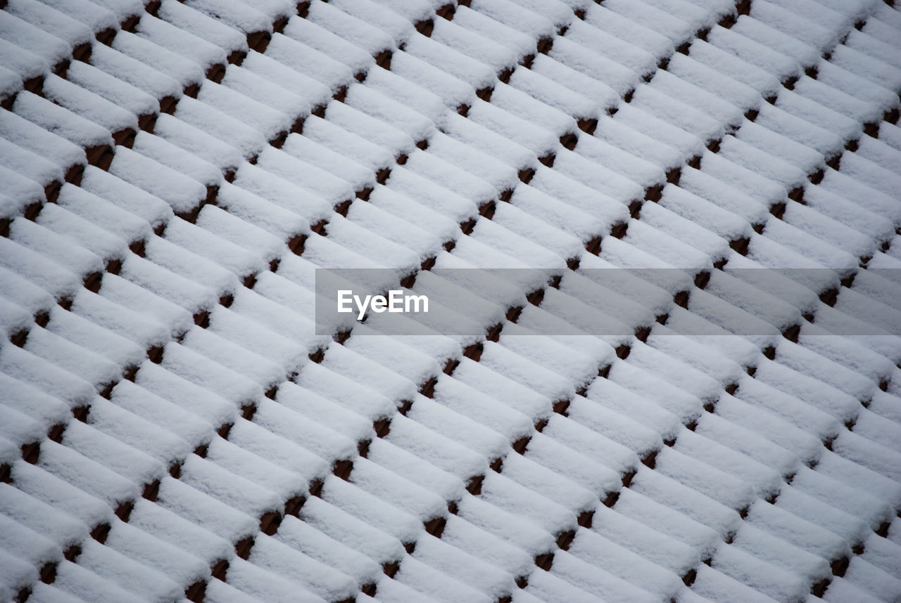 Abstract pattern of snow covered roof tiles