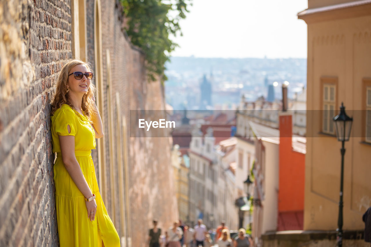 Woman in yellow dress traveling in city