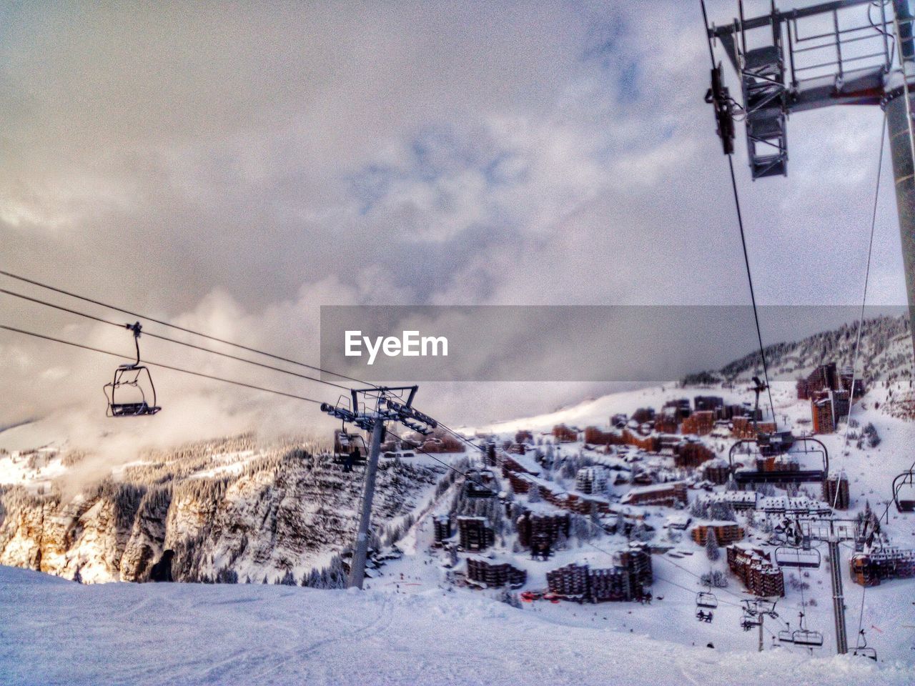 SKI LIFT OVER SNOW COVERED MOUNTAINS