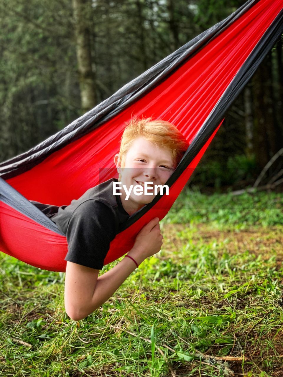 Portrait of smiling boy laying in hammock 