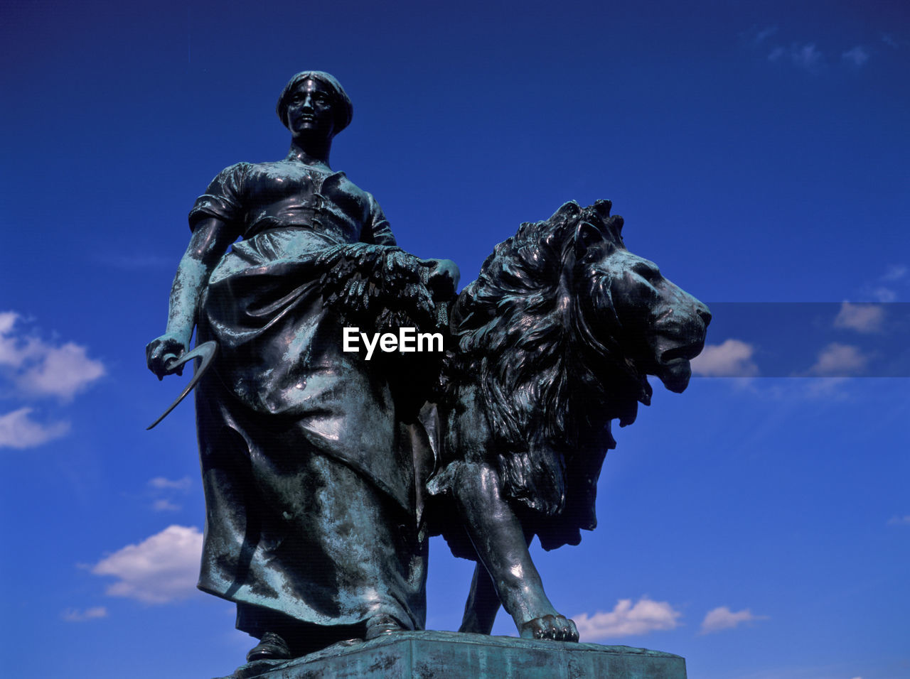 LOW ANGLE VIEW OF STATUES AGAINST BLUE SKY