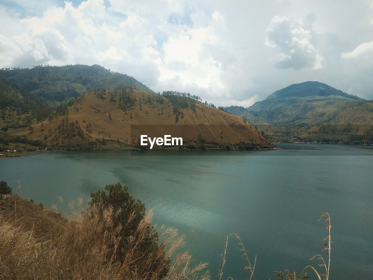 Scenic view of lake by mountains against sky