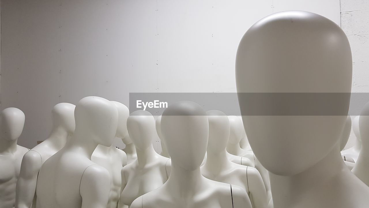 Close-up of mannequins against wall