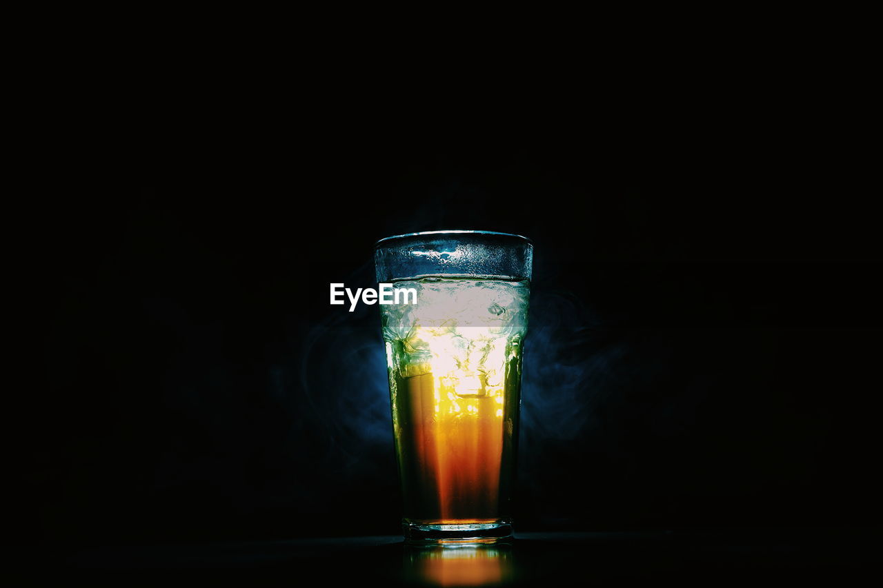 Close-up of drink in glass on table against black background