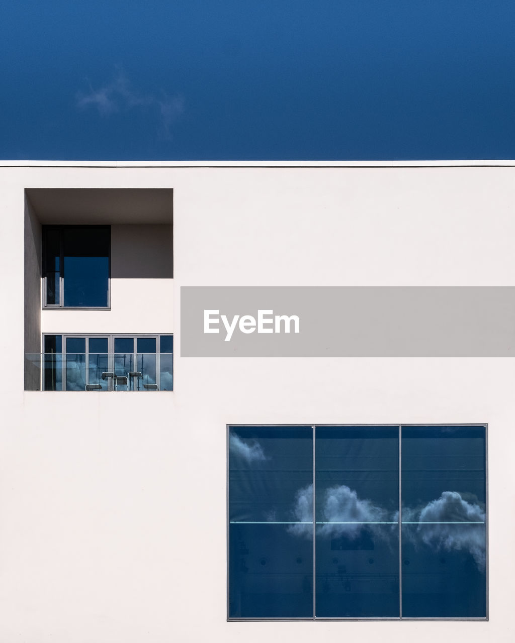 DIGITAL COMPOSITE IMAGE OF MODERN BUILDING AGAINST BLUE SKY