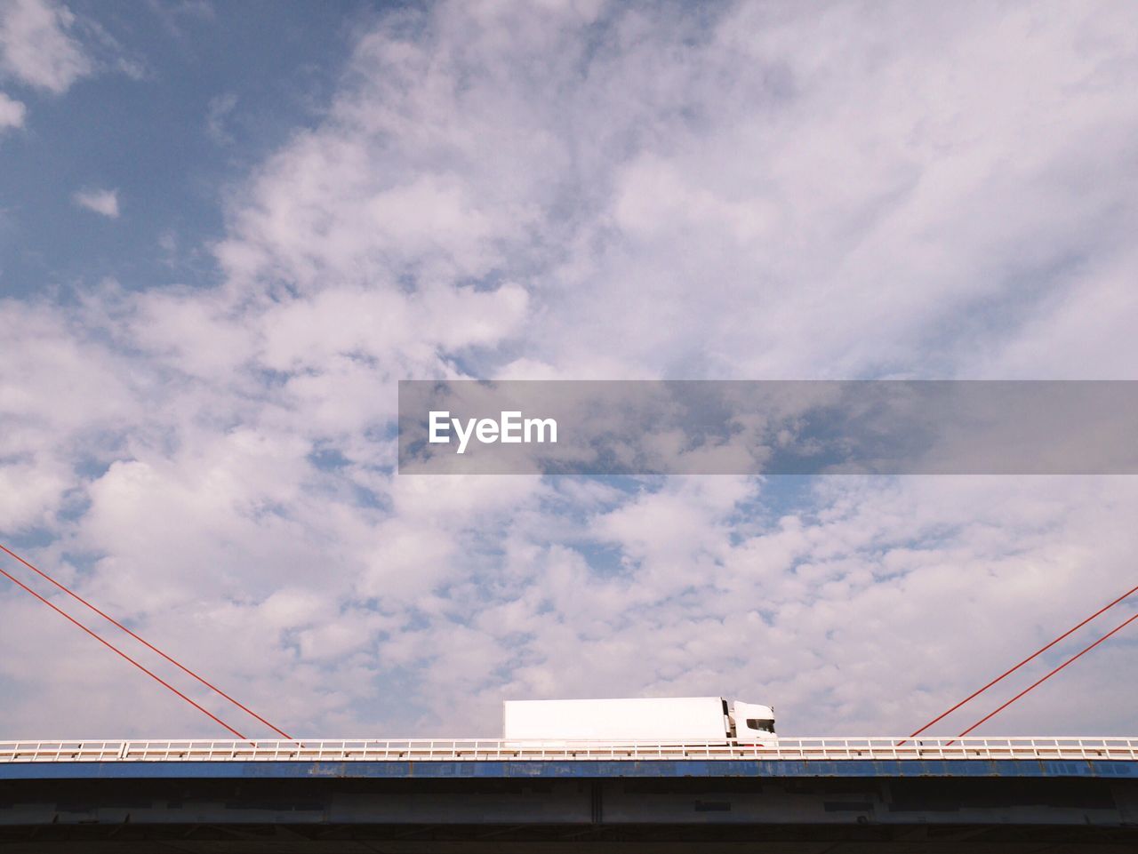 Low angle view of truck on bridge against sky