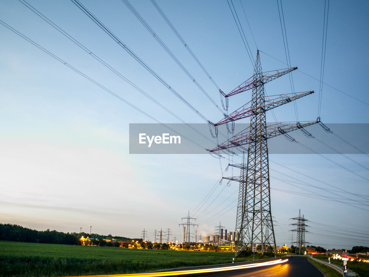 Low angle view of silhouette electricity pylon against sky at dusk