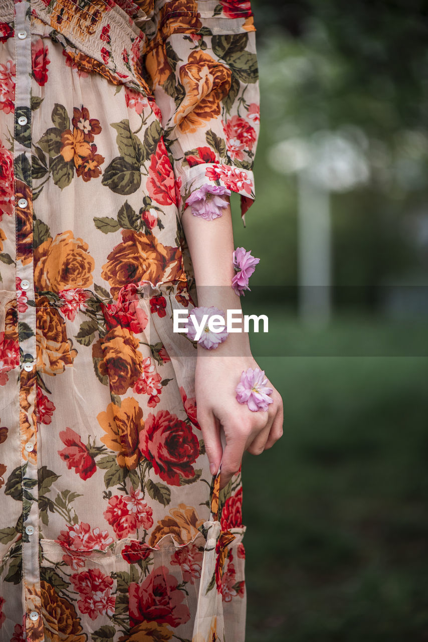 Midsection of woman with flowers