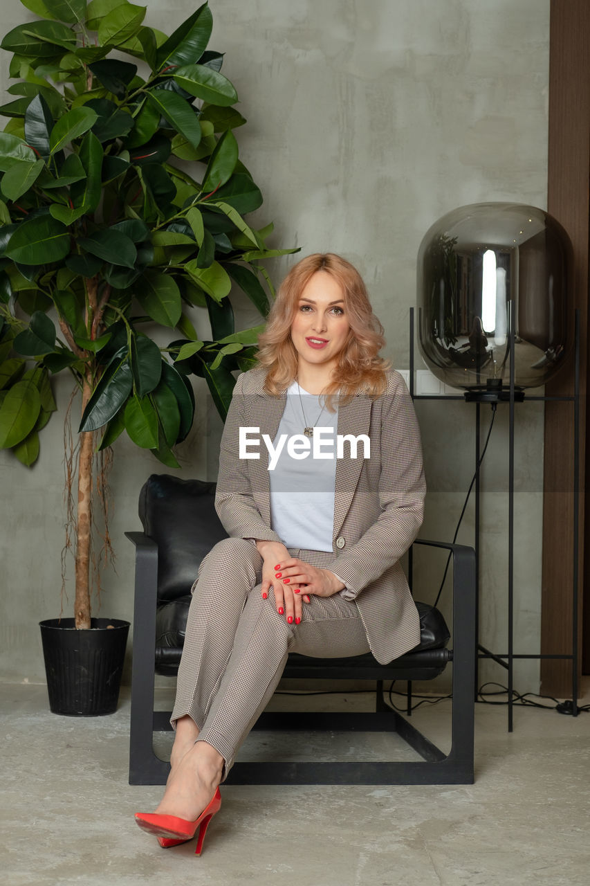 Woman sitting on a chair. portrait of a strong businesswoman. the girl in a classic suit 