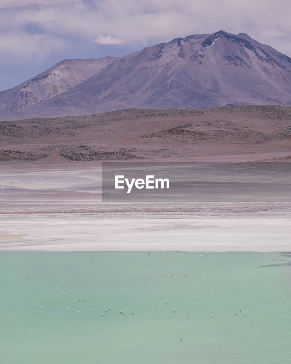 Scenic view of lake and mountains against cloudy sky