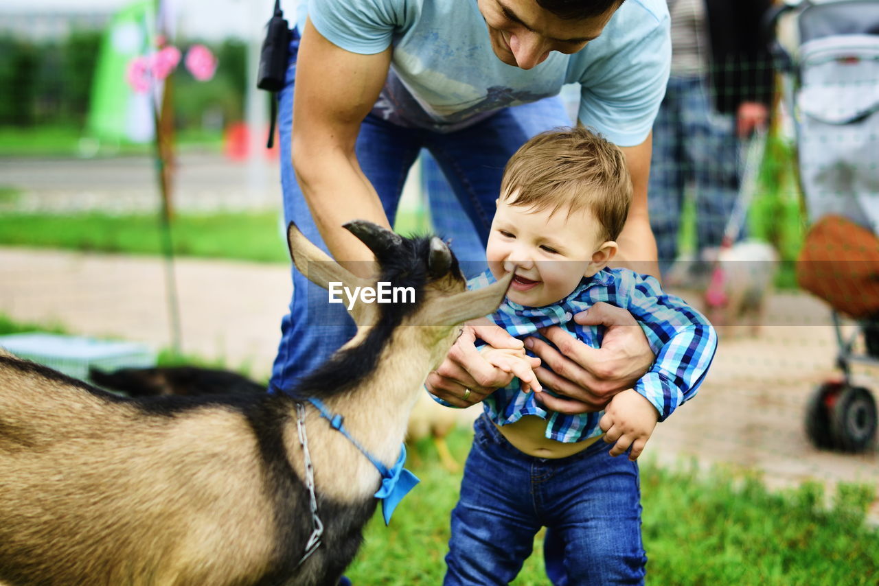 Boy smiling at goat