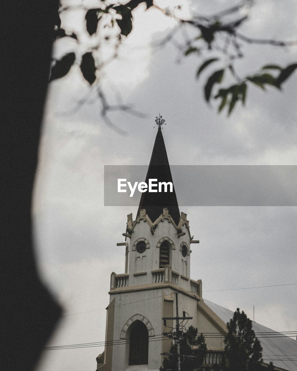 LOW ANGLE VIEW OF BELL TOWER AGAINST CLOUDY SKY