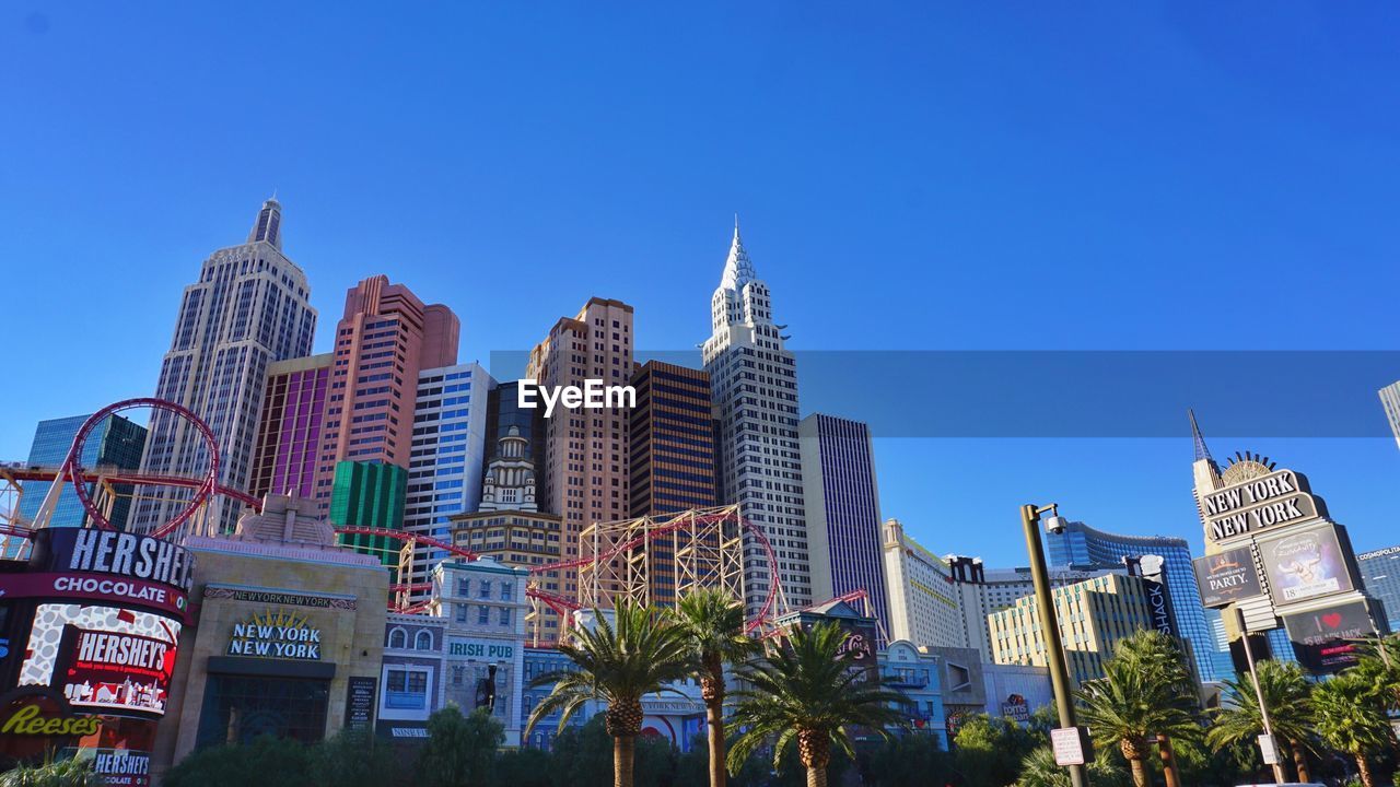 LOW ANGLE VIEW OF MODERN BUILDINGS AGAINST BLUE SKY