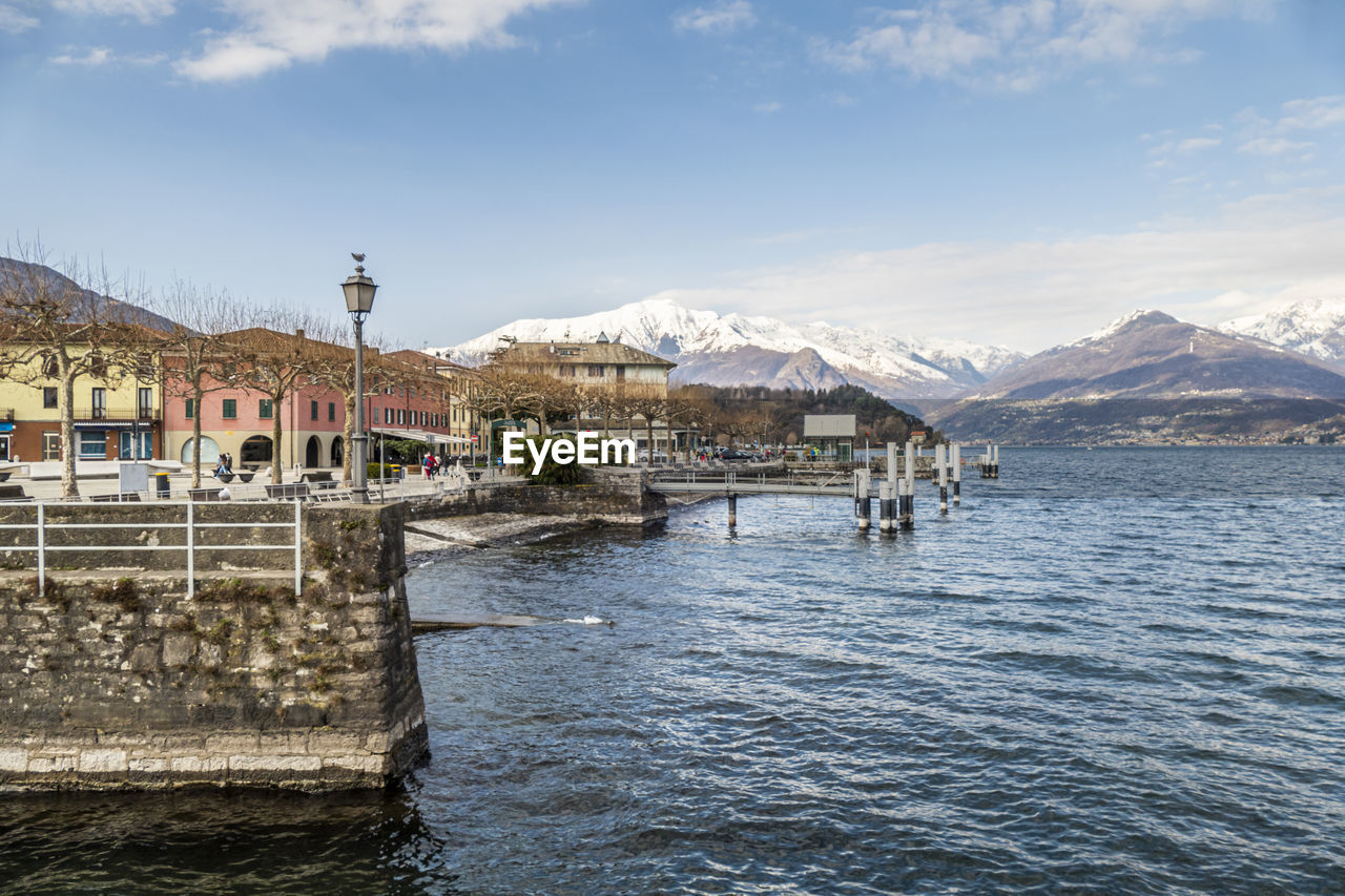 The lakeside promenade of colico with the snow-capped alps in the background