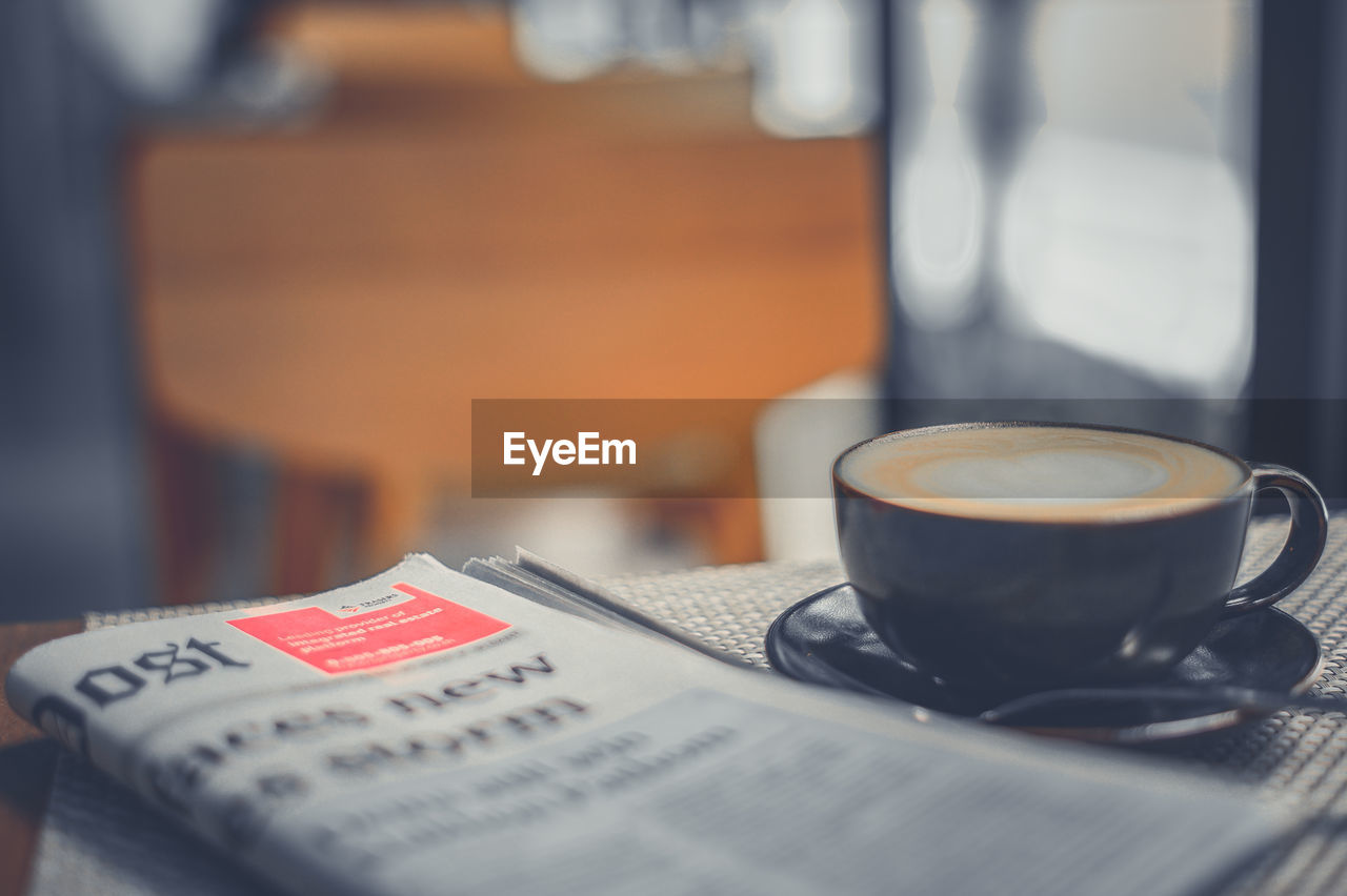 COFFEE CUP ON TABLE WITH TEXT