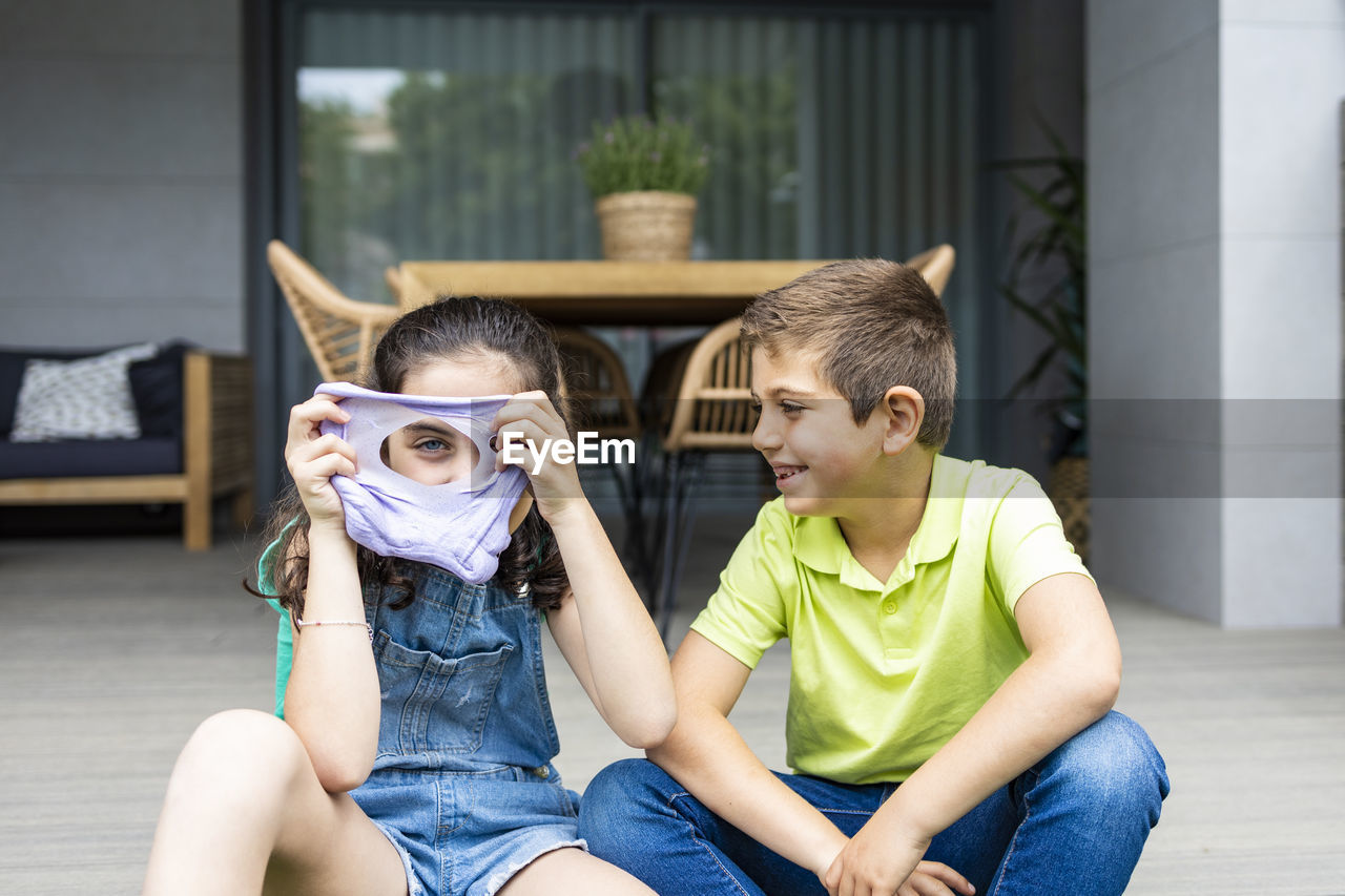 Two kids playing with a slime at home