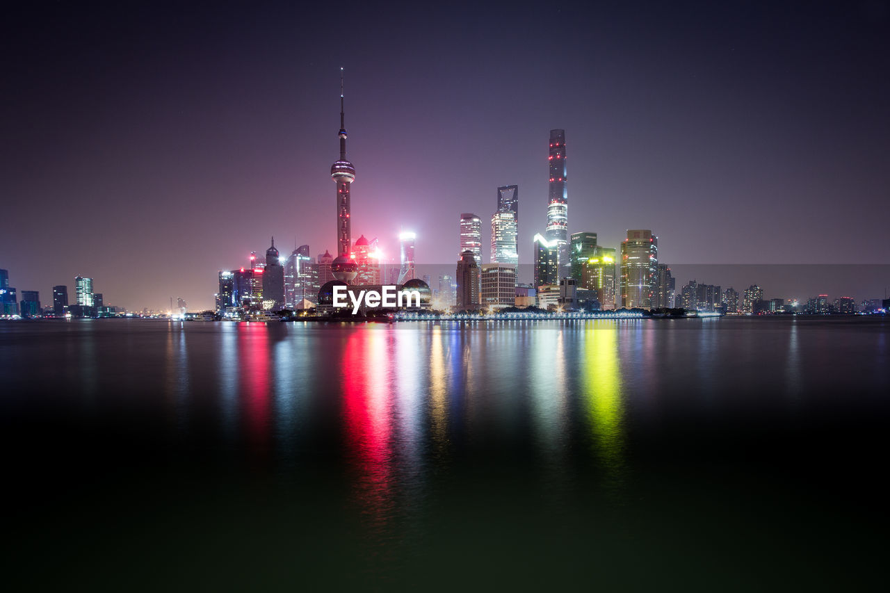 Reflection of illuminated buildings in river at night