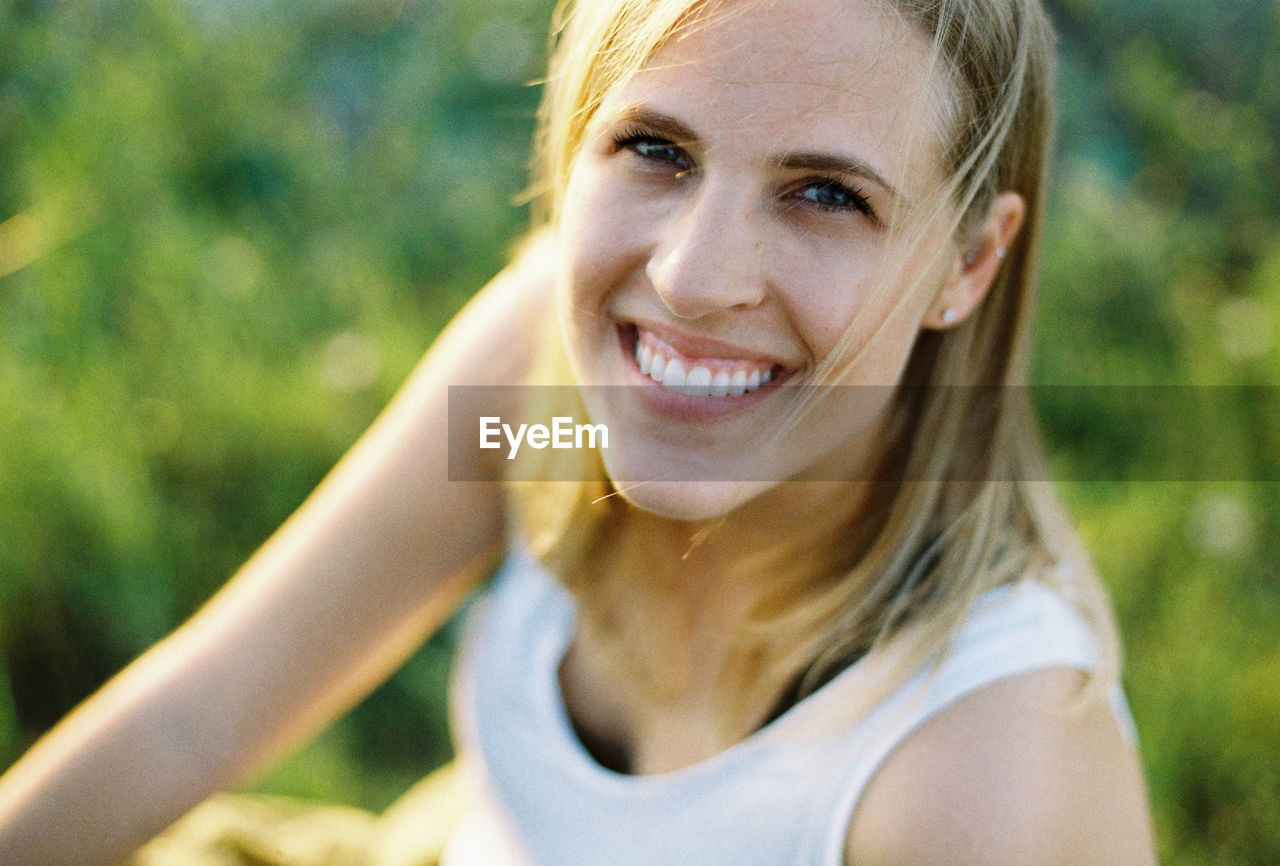 Close-up portrait of smiling woman in sunny day