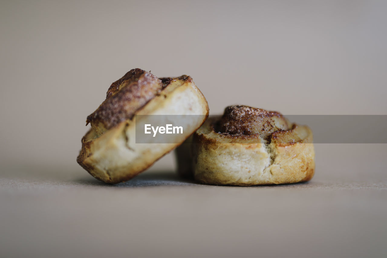 Photo of two cinnamon rolled cakes on clean netural background. fresh baked.